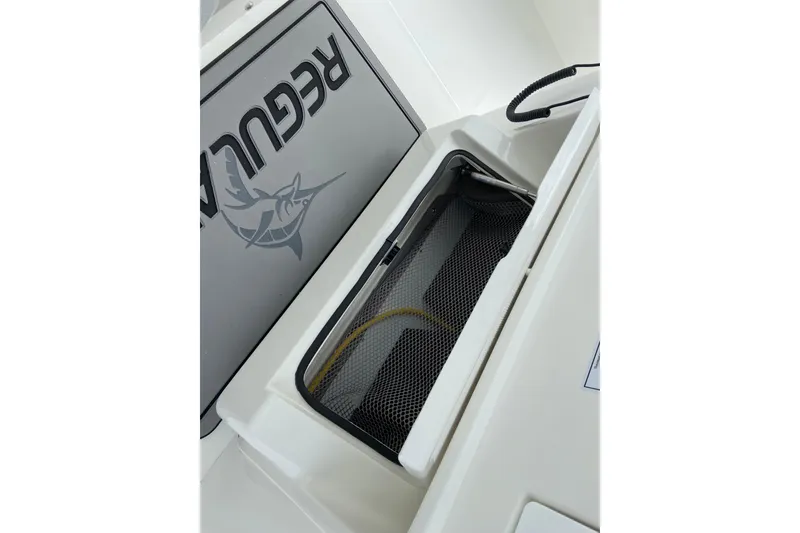 Slide: The Image of 2027 Regulator 26XO boat interior with storage compartment and logo detail. - 47