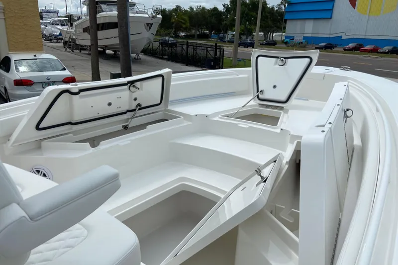 Slide: The Image of 2027 Regulator 26XO boat with open storage compartments and sleek white design. - 49
