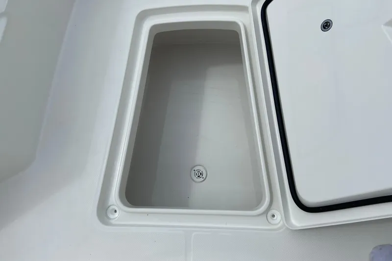 Slide: The Image of Storage compartment on a 2027 Regulator 26XO boat, featuring a drain plug. - 50