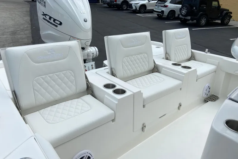 Slide: The Image of 2027 Regulator 26XO boat interior with white cushioned seats and cup holders. - 9