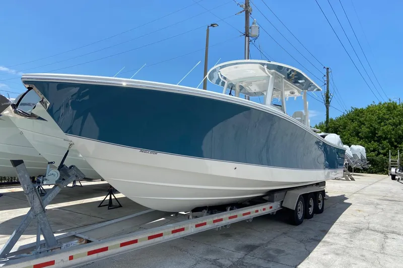The Image of 2027 Regulator 35 boat on trailer, blue and white hull, parked outdoors. - 0