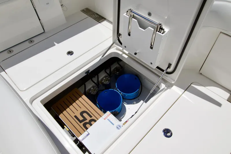Slide: The Image of Storage compartment of 2027 Regulator 35 boat with blue buckets and equipment. - 10