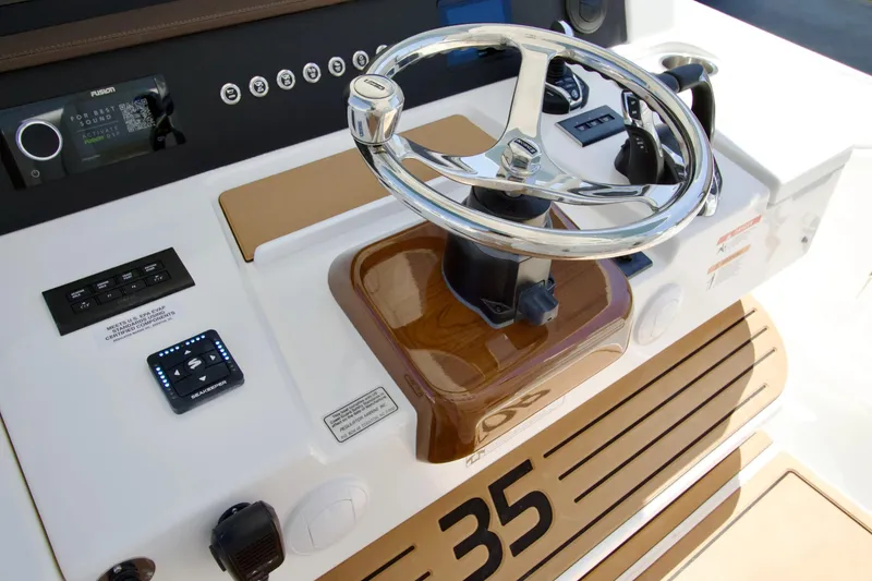 Slide: The Image of 2027 Regulator 35 boat helm with modern controls and sleek steering wheel design. - 18