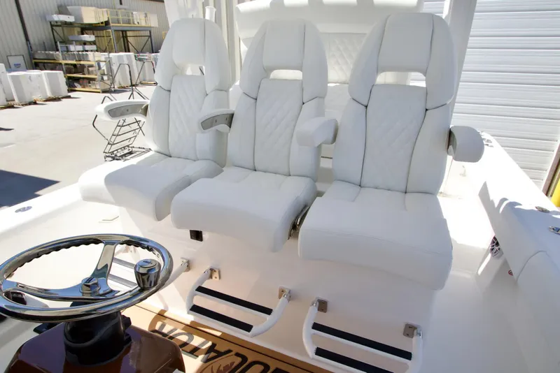 Slide: The Image of Luxury seating on 2027 Regulator 35 boat with white leather upholstery and steering wheel. - 24
