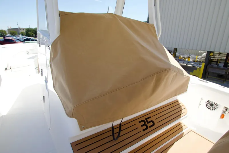 Slide: The Image of 2027 Regulator 35 boat with tan cover on deck, showcasing sleek design. - 33