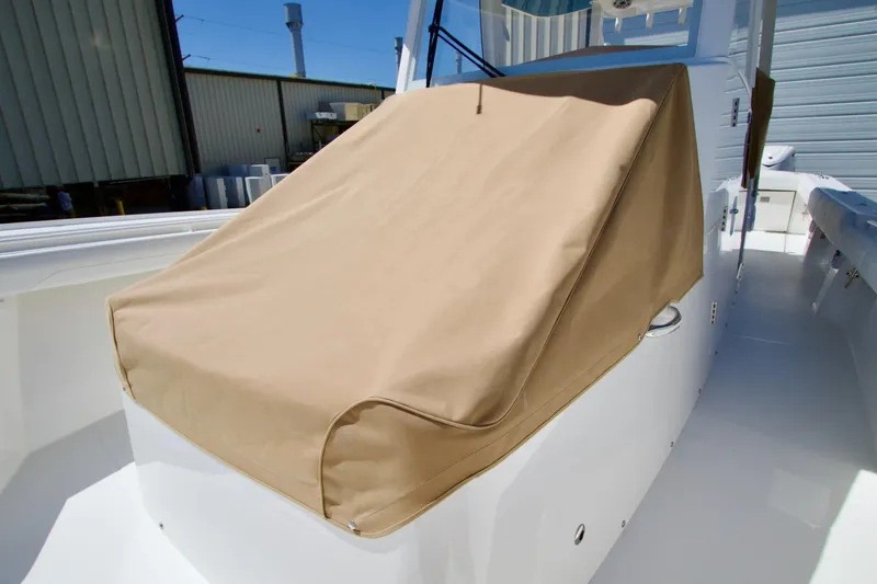 Slide: The Image of 2027 Regulator 35 boat with tan cover, docked outdoors. - 35