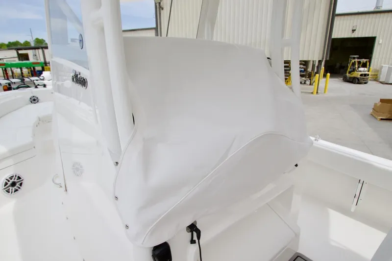 Slide: The Image of 2026 Regulator 26XO boat console covered, docked near industrial building. - 30