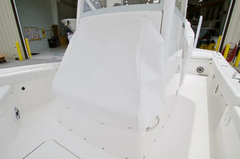 Slide: The Image of 2026 Regulator 26XO boat interior with white console cover in a warehouse setting. - 32