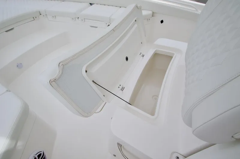 Slide: The Image of 2026 Regulator 26XO boat interior with open storage compartment and cushioned seating. - 6