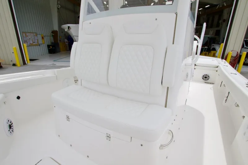 Slide: The Image of 2026 Regulator 26XO boat interior with white cushioned seating and storage compartment. - 7