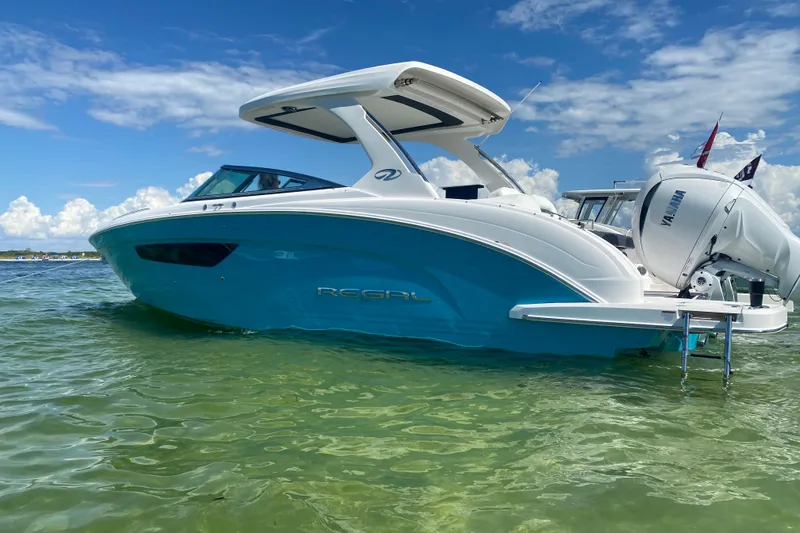 The Image of 2022 Regal 33 OBX boat in clear water, showcasing sleek design and Yamaha outboard motor. - 0