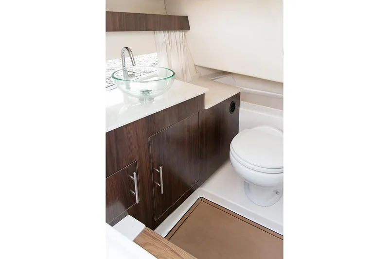 Slide: The Image of Manufacturer Provided Image: 2022 Regal 33 OBX boat bathroom with modern sink and wooden cabinetry. - 15