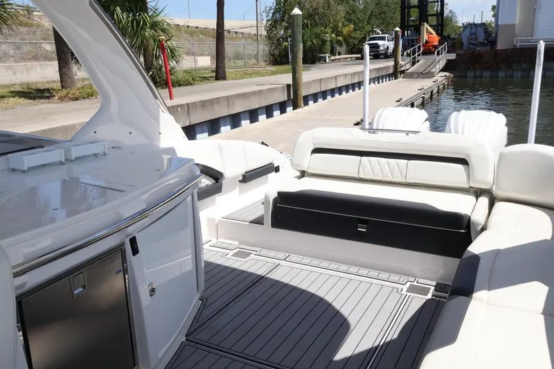 Slide: The Image of 2022 Regal 33 OBX boat interior with luxurious seating and sleek design at a dock. - 18
