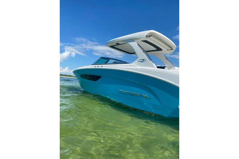 Slide: The Image of 2022 Regal 33 OBX boat on clear water under blue sky. - 2