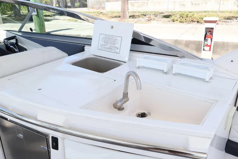 Slide: The Image of 2022 Regal 33 OBX boat kitchenette with sink, faucet, and storage compartments. - 23