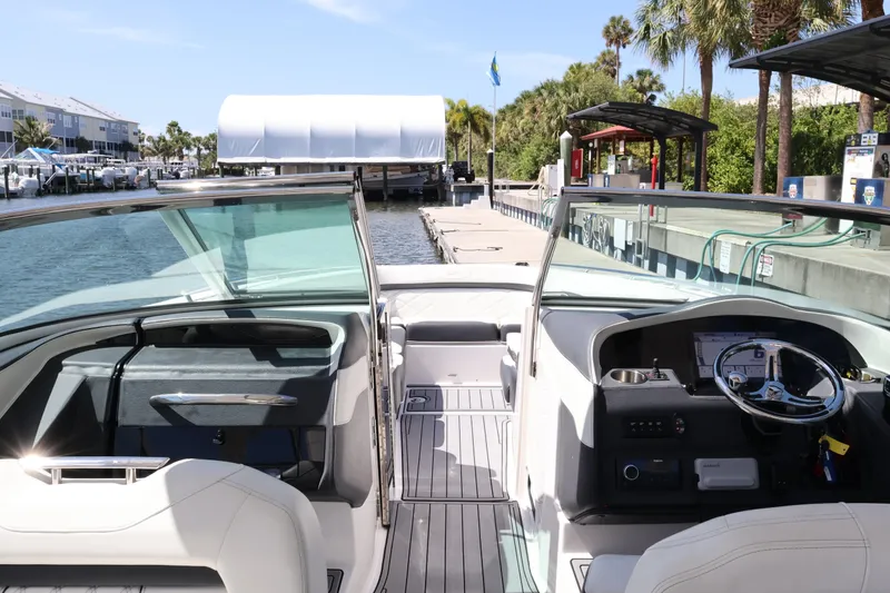 Slide: The Image of 2022 Regal 33 OBX boat interior at marina dock, featuring modern dashboard and seating. - 24