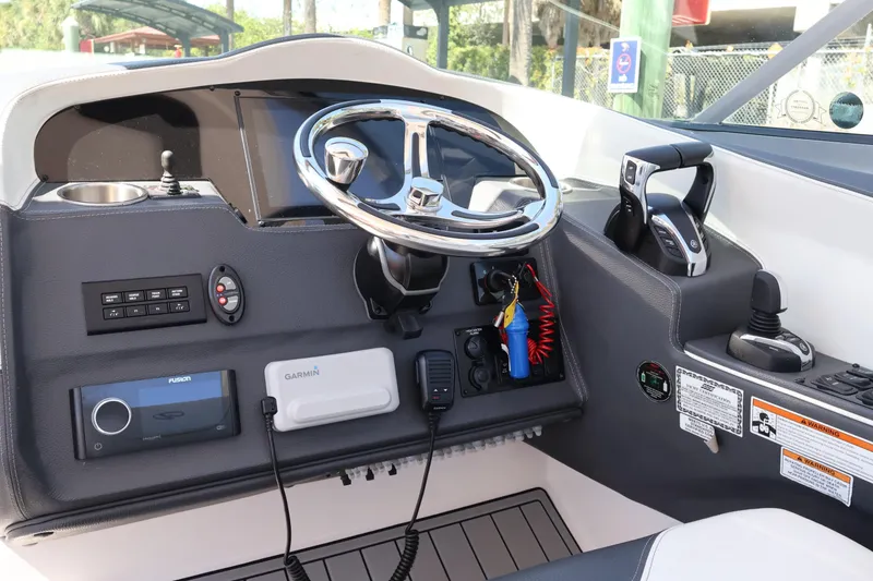 Slide: The Image of 2022 Regal 33 OBX boat dashboard with steering wheel, controls, and navigation equipment. - 26