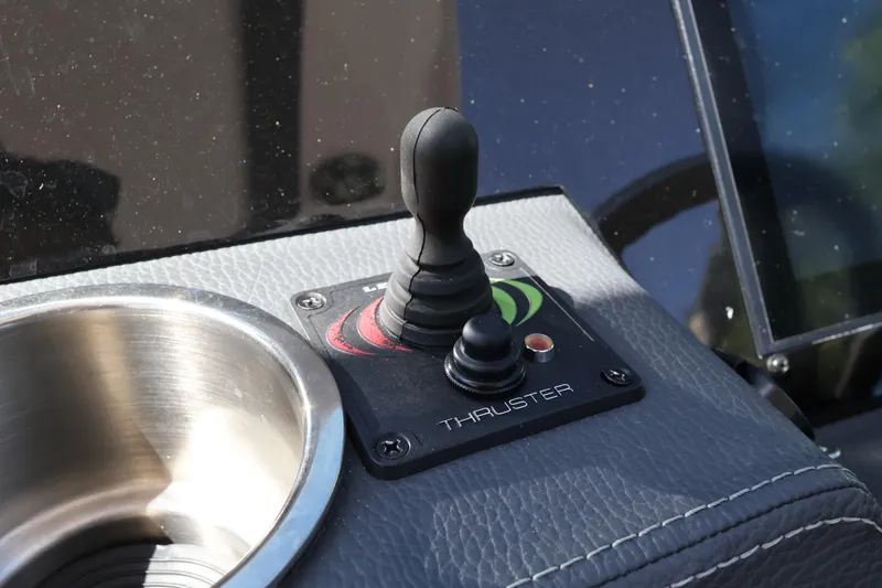 Slide: The Image of Joystick control on 2022 Regal 33 OBX boat dashboard with cup holder. - 27