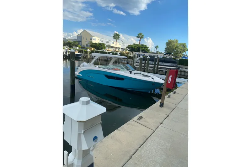 Slide: The Image of 2022 Regal 33 OBX boat docked at a marina under a clear blue sky. - 3