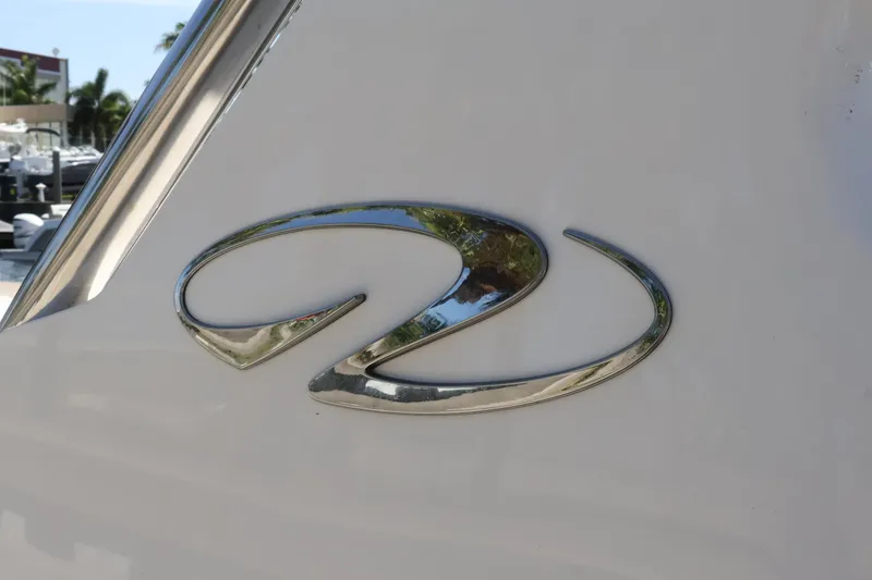 Slide: The Image of Chrome emblem on 2022 Regal 33 OBX boat, reflecting surroundings. - 49