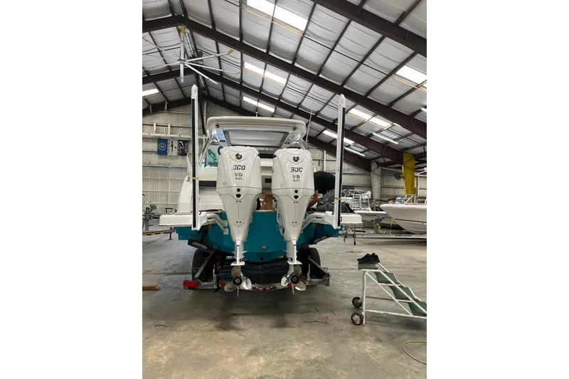 Slide: The Image of 2022 Regal 33 OBX boat with twin outboard engines in a warehouse. - 5