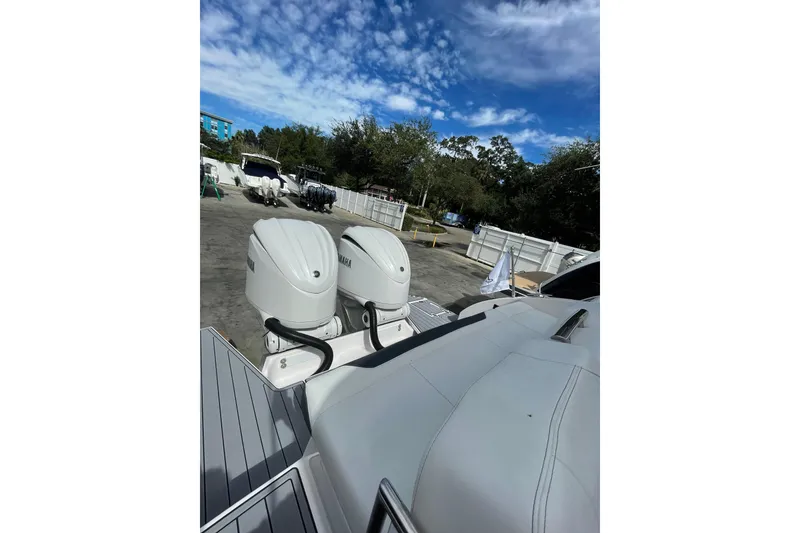 Slide: The Image of 2022 Regal 33 OBX boat with dual Yamaha outboard engines, parked outdoors. - 6