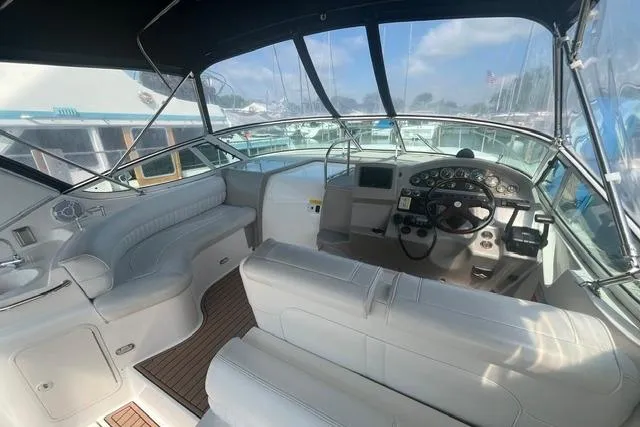 Slide: The Image of 2004 Cruisers Yachts 3372 Express cockpit with white seating and modern dashboard controls. - 19