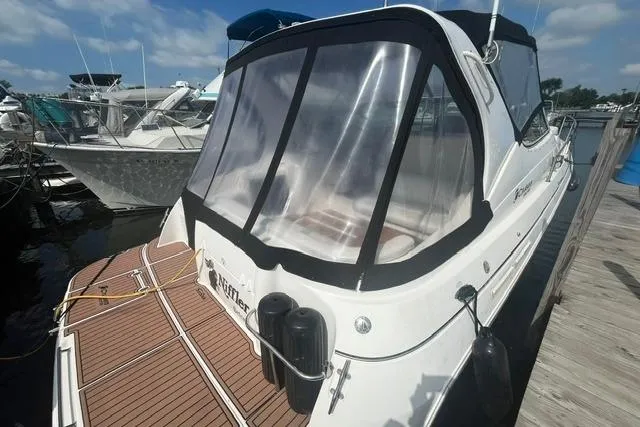 Slide: The Image of 2004 Cruisers Yachts 3372 Express docked, featuring sleek design and clear canopy. - 2
