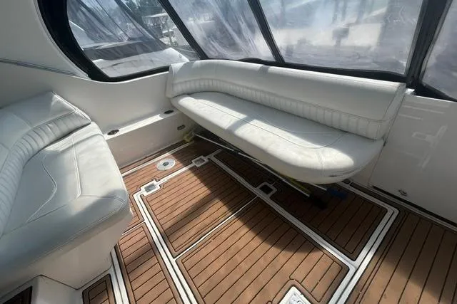 Slide: The Image of 2004 Cruisers Yachts 3372 Express interior with white seating and wooden flooring. - 25