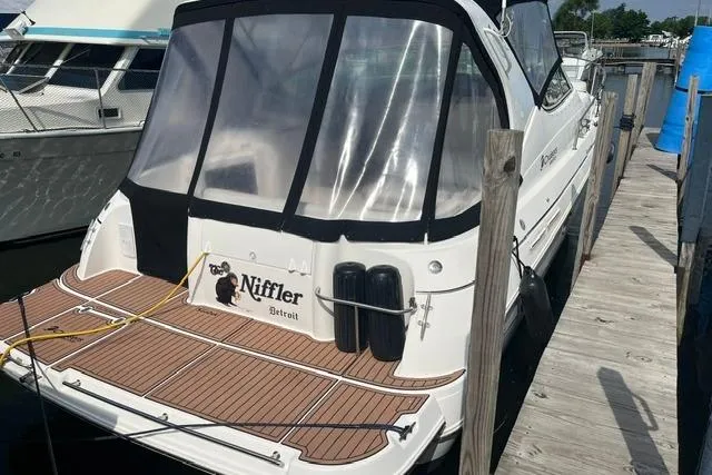 Slide: The Image of 2004 Cruisers Yachts 3372 Express docked, featuring a sleek design and spacious deck. - 3