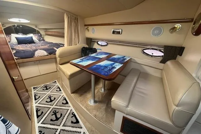 Slide: The Image of 2004 Cruisers Yachts 3372 Express cabin interior with dining area and cozy sleeping quarters. - 39