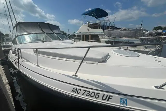Slide: The Image of 2004 Cruisers Yachts 3372 Express docked under a partly cloudy sky. - 4