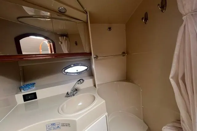 Slide: The Image of 2004 Cruisers Yachts 3372 Express bathroom with sink, mirror, and shower curtain. - 47