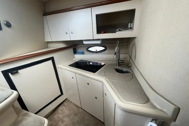 Slide: The Image of 2004 Cruisers Yachts 3372 Express interior kitchen with sink, stove, and storage cabinets. - 52