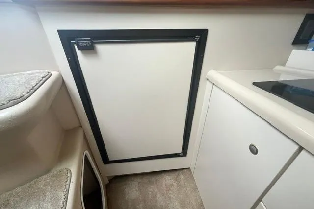 Slide: The Image of Interior view of 2004 Cruisers Yachts 3372 Express, featuring a compact kitchenette area. - 53