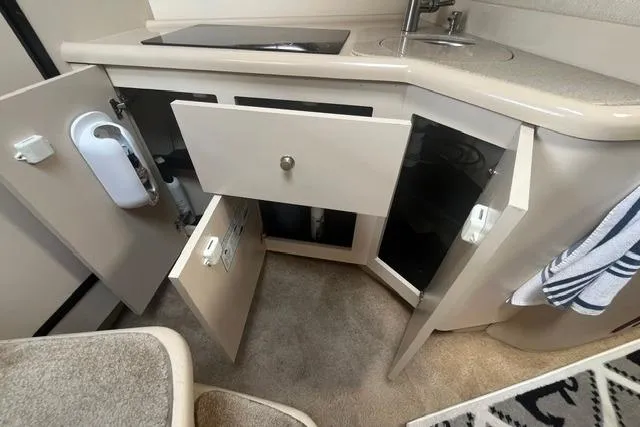 Slide: The Image of 2004 Cruisers Yachts 3372 Express interior kitchen with open cabinets and sink. - 55