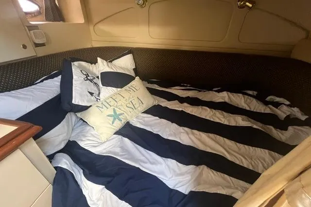 Slide: The Image of Cozy cabin interior of 2004 Cruisers Yachts 3372 Express with striped bedding and nautical decor. - 59