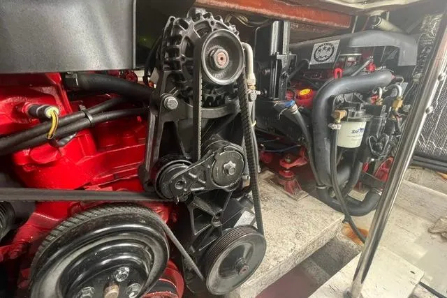 Slide: The Image of Engine compartment of 2004 Cruisers Yachts 3372 Express, showcasing mechanical components and belts. - 62