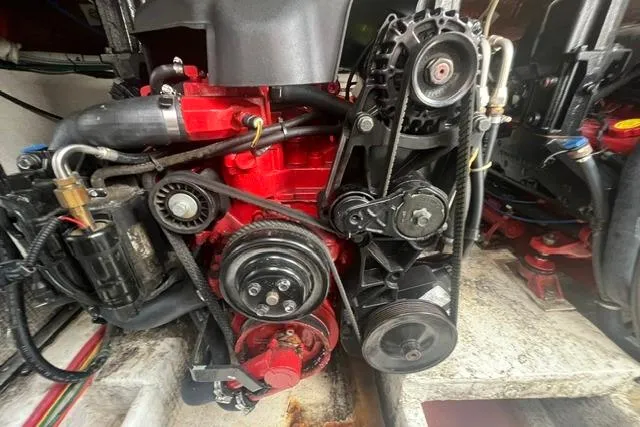 Slide: The Image of Engine compartment of a 2004 Cruisers Yachts 3372 Express, showcasing mechanical components and belts. - 63