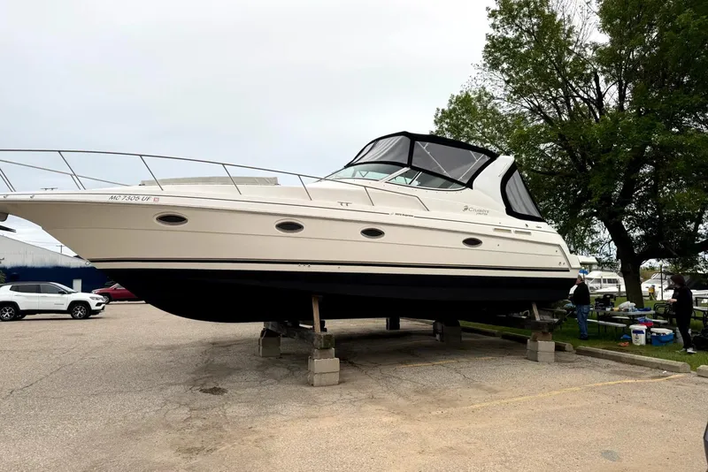 Slide: The Image of 2004 Cruisers Yachts 3372 Express boat on blocks in a parking area. - 8