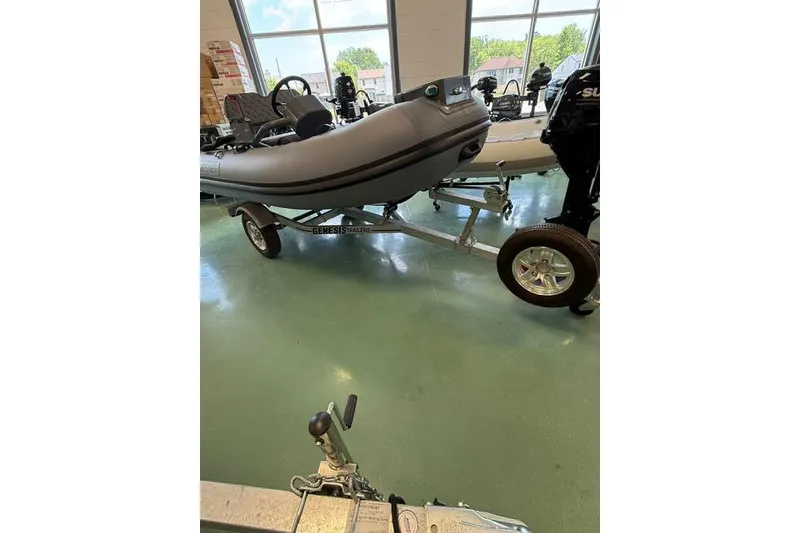 Slide: The Image of 2026 Desner CL310 FCT boat on Genesis trailer in showroom. - 11