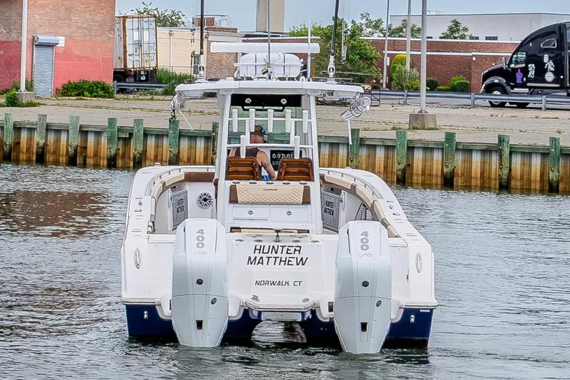 Slide: The Image of 2024 Caymas 34 CT boat with triple engines docked in a marina. - 7