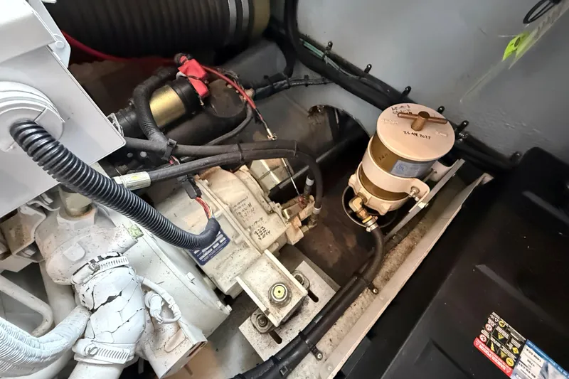 Slide: The Image of Engine compartment of a 1999 Mainship 350 Trawler, showcasing mechanical components and wiring. - 33