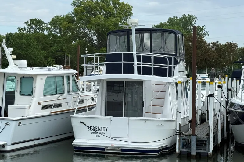Slide: The Image of 1999 Mainship 350 Trawler docked, featuring "Serenity" name, surrounded by other boats. - 3