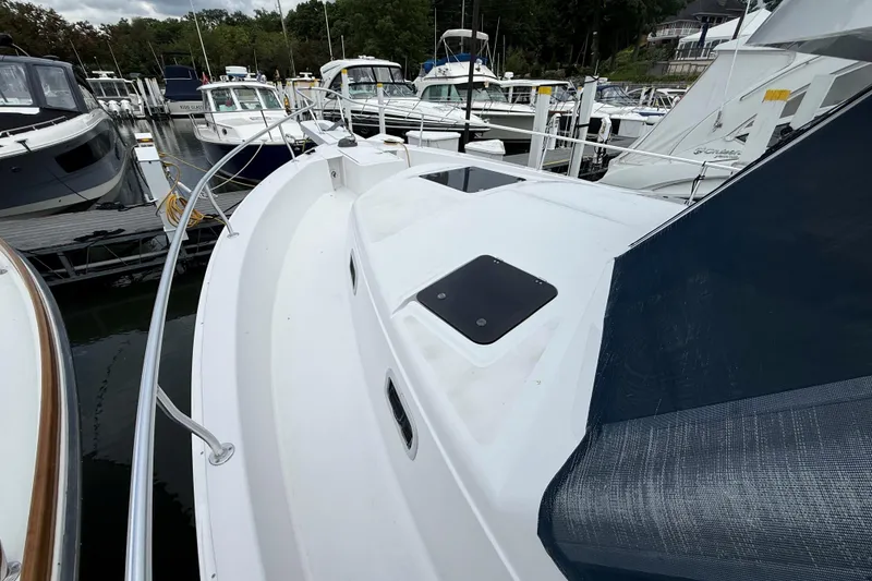 Slide: The Image of 1999 Mainship 350 Trawler docked at marina, surrounded by other boats. - 6