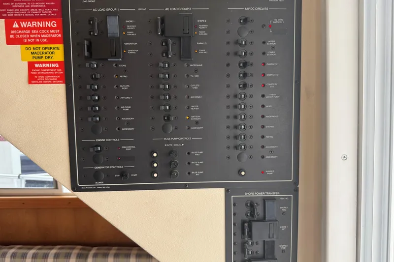 Slide: The Image of Control panel of a 1999 Mainship 350 Trawler with various switches and warning labels. - 22