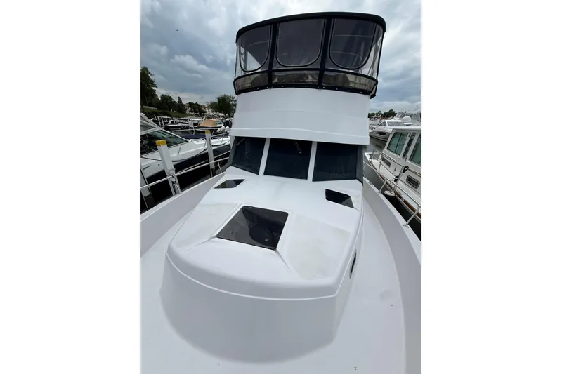 Slide: The Image of 1999 Mainship 350 Trawler with enclosed flybridge, docked at marina under cloudy skies. - 8