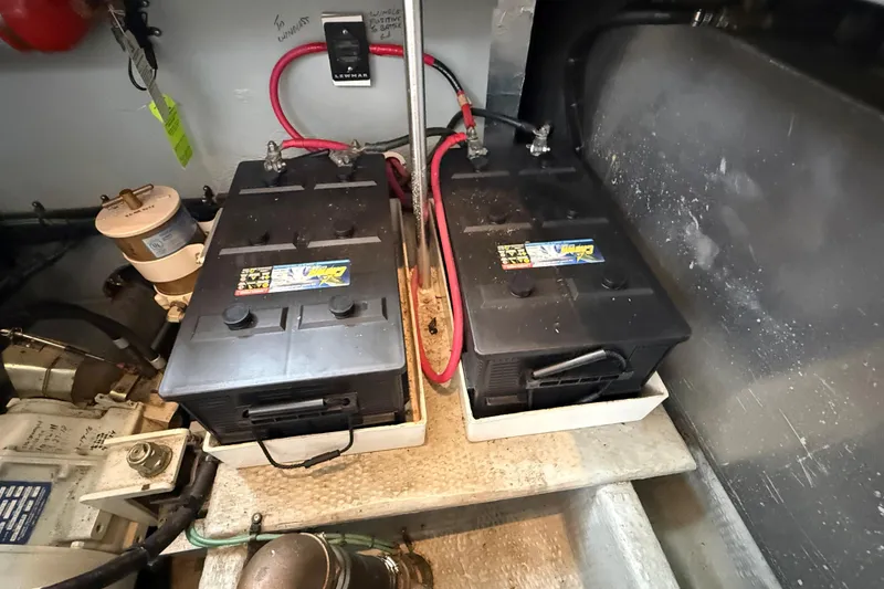Slide: The Image of Battery compartment of a 1999 Mainship 350 Trawler with dual batteries and wiring. - 32