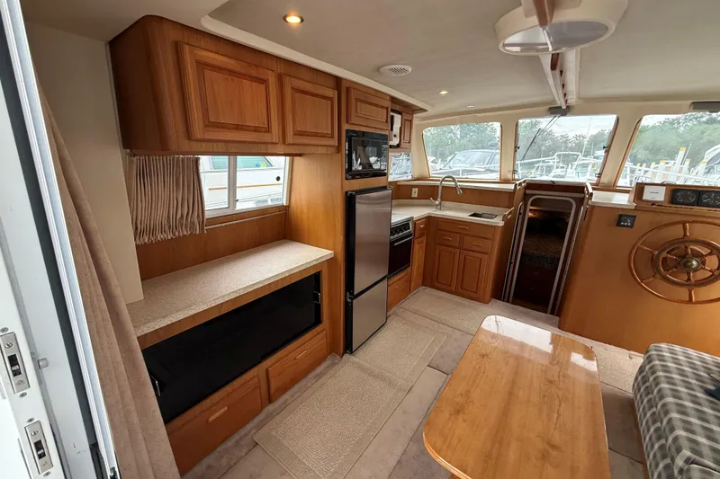 Slide: The Image of Interior of a 1999 Mainship 350 Trawler with wood cabinetry and modern appliances. - 17