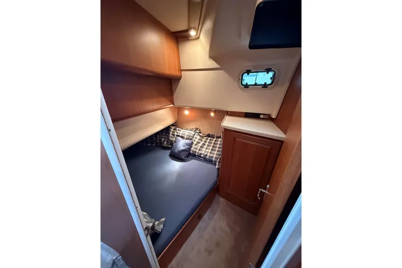 Slide: The Image of Cozy cabin interior of 1999 Mainship 350 Trawler with bed and wooden cabinetry. - 26